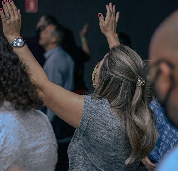 People raising their hands in a meeting room