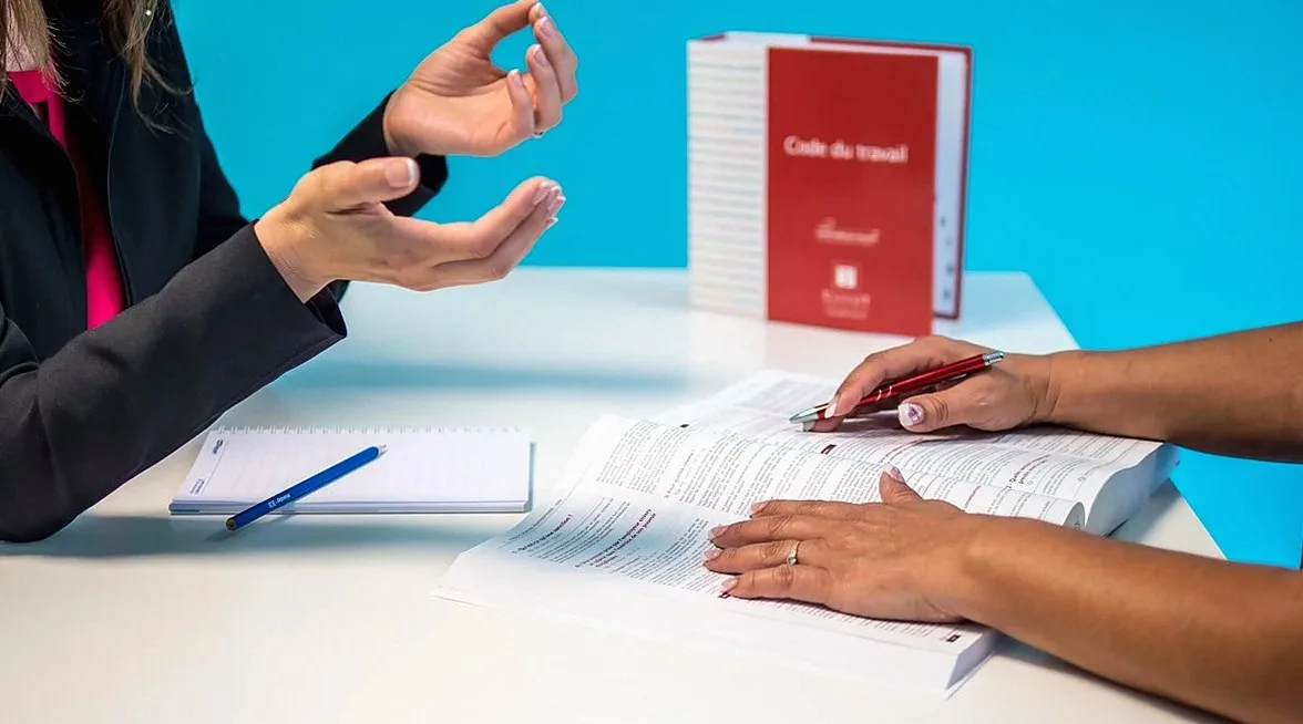 Hands resting on printed documents at a table during a meeting